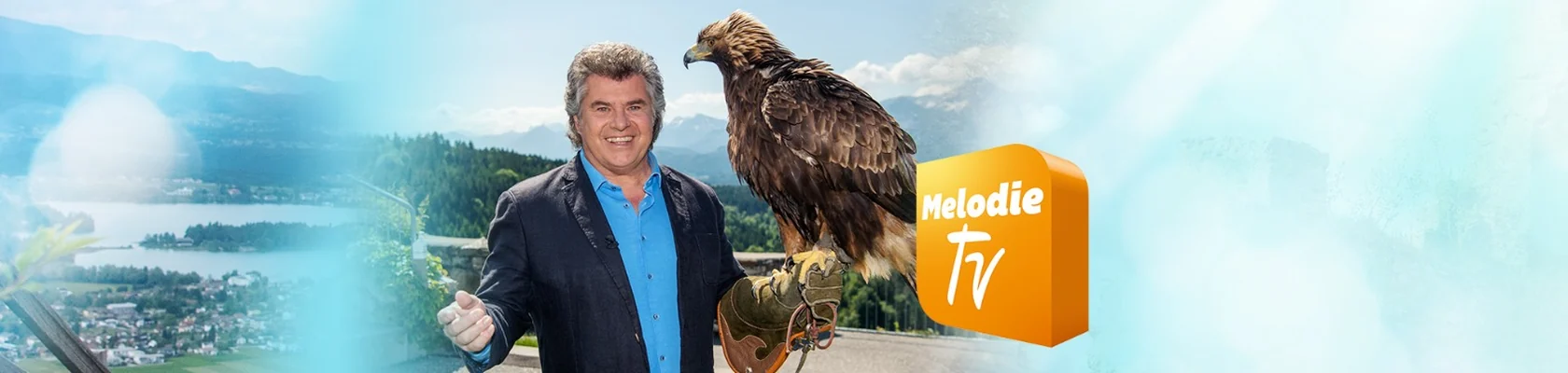 Moderator mit Adler vor einer Seenlandschaft