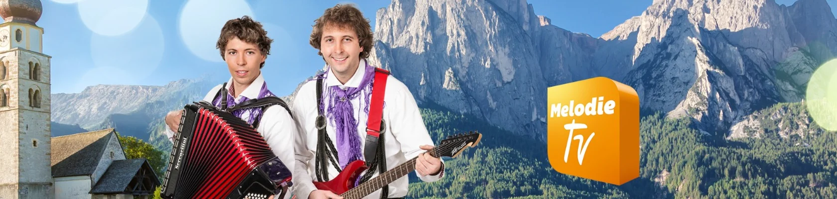 Musiker vor einer Kirche und Bergkulisse